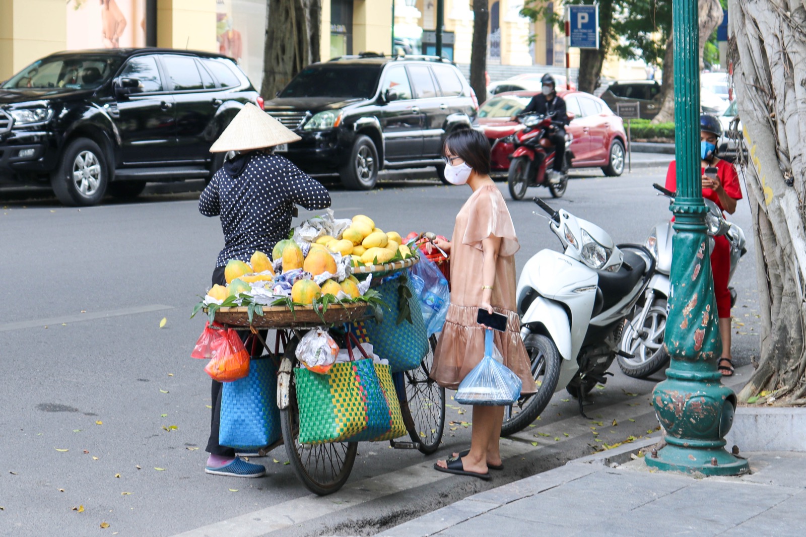 Người bán rong đứng bên xe đẩy đầy xoài ở Việt Nam